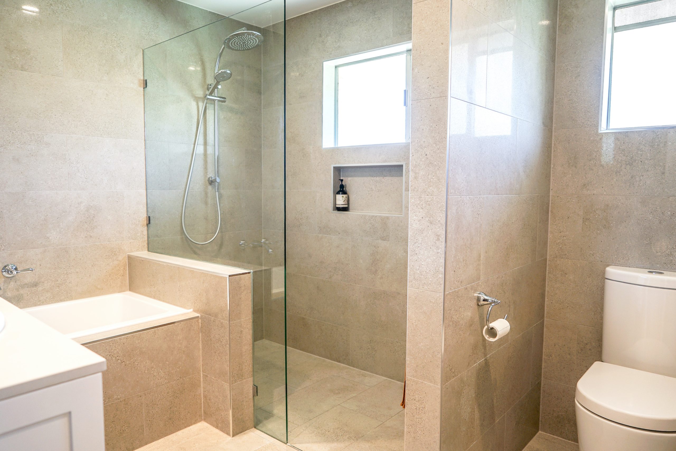a newly renovated bathroom on the Sunshine Coast with sandstone-look tiling
