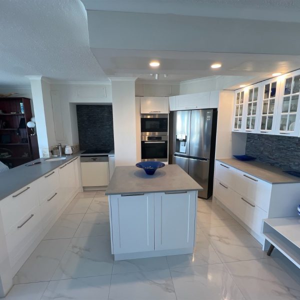 a kitchen with white cabinets and a blue bowl on a island