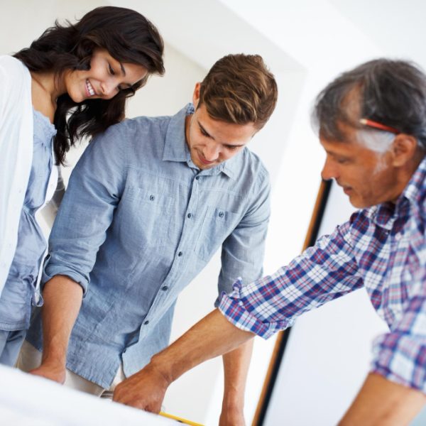 a group of people looking at a blueprint