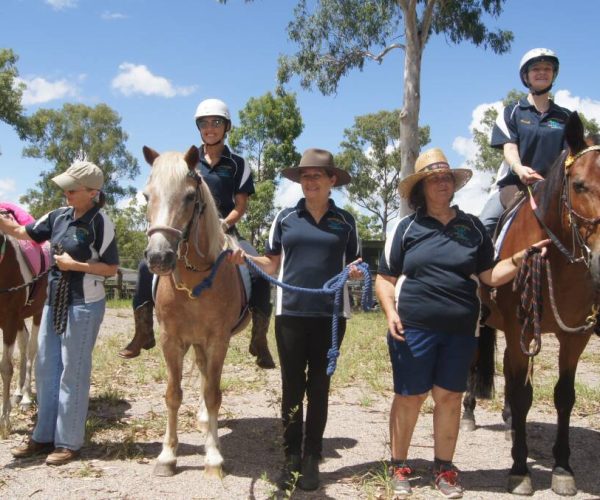 a group of people standing with horses